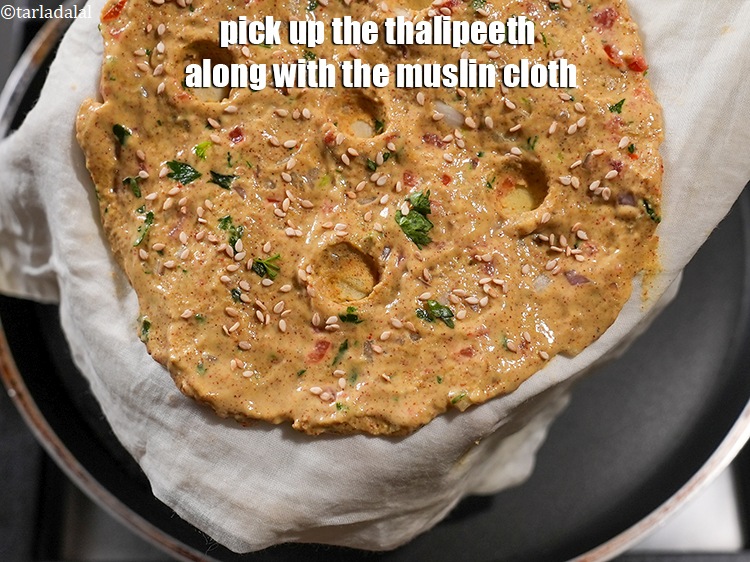 Step 26 – Pick up the thalipeeth&nbsp;along with the muslin cloth.