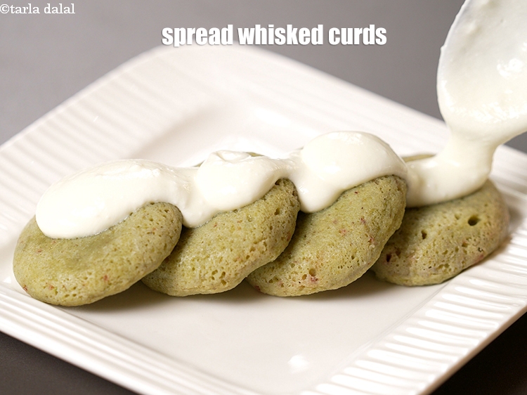 Step 25 – Spread &frac14; cup of <a href="https://www.tarladalal.com/glossary-whisked-curds--2096i">whisked curds (dahi)</a>&nbsp;/&nbsp;<a href="https://www.tarladalal.com/glossary-low-fat-curds-low-cal-dahi-low-calorie-curd-low-fat-yogurt-1107i">low fat curds (dahi)</a> evenly.