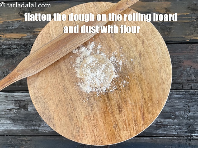 स्टेप 27 – आटे को चकले पर फैलाकर उस पर आटा छिड़कें।