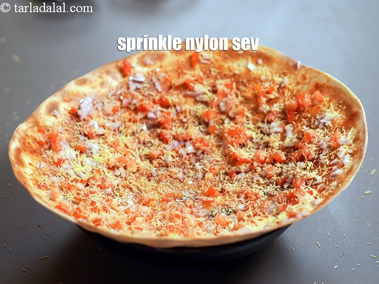 Step 26 – Sprinkle <a href="https://www.tarladalal.com/glossary-nylon-sev-2630i">nylon sev</a> evenly over it.