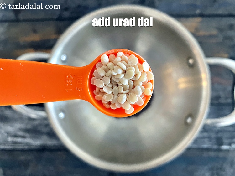 Step 25 – Add&nbsp;<meta charset="UTF-8" />2 tsp&nbsp;<a href="glossary-urad-dal-split-black-lentil-941i">urad dal (split black lentils)</a>.