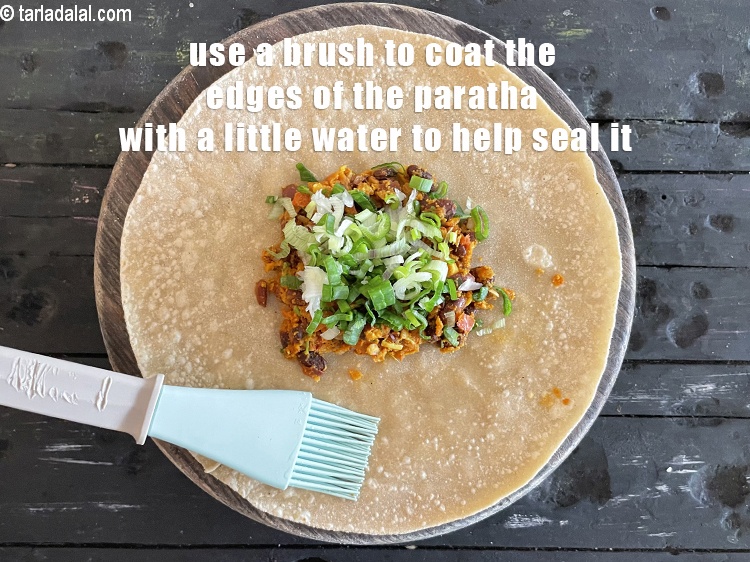 Step 44 – Use a brush and coat the edges of the paratha with a little water which …