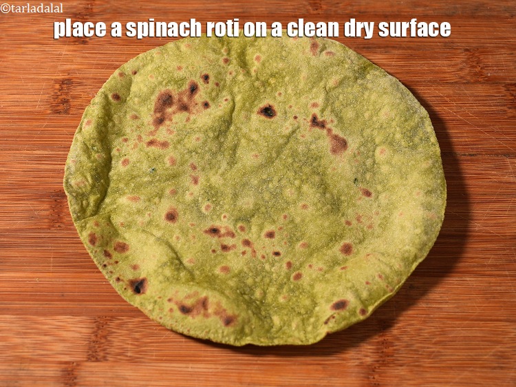 Step 28 – <meta charset="UTF-8" />Place a spinach roti on a clean dry surface.