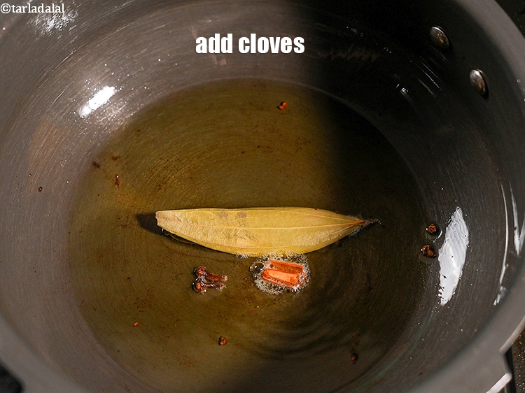 Step 26 – Add 2 <a href="https://www.tarladalal.com/glossary-cloves-laung-lavang-322i">cloves (laung / lavang)</a>.&nbsp;