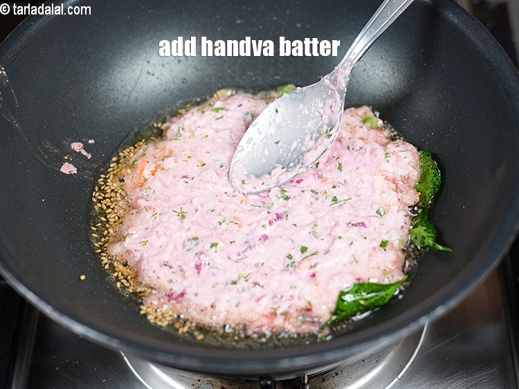 Step 26 – Once crackled, add 1 portion of the handva batter.