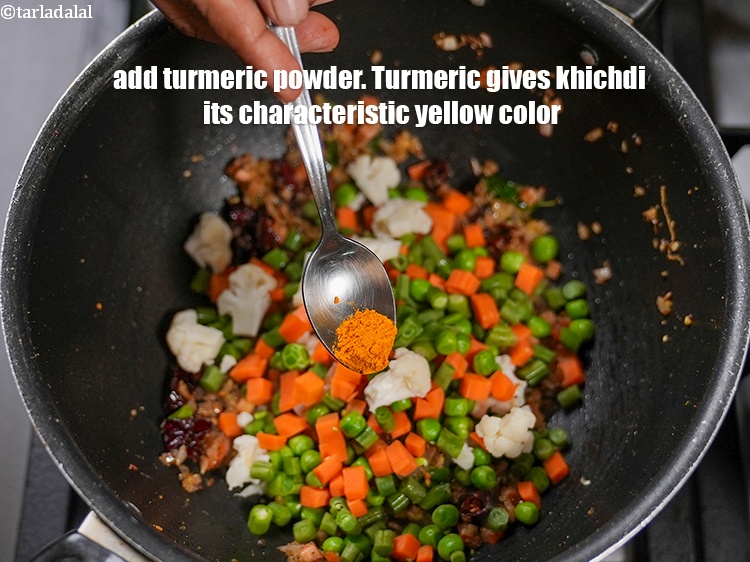 Step 26 – Add &frac12; tsp <a href="https://www.tarladalal.com/glossary-turmeric-powder-haldi-645i">turmeric powder (haldi)</a>. Turmeric gives khichdi its characteristic yellow color.