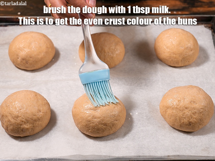 स्टेप 26 – आटे पर&nbsp;१ टेबल-स्पून&nbsp;<a href=""https://www.tarladalal.com/glossary-milk-doodh-full-cream-milk-hindi-514i"">दूध</a>&nbsp;लगाएं । ऐसा करने से बन्स की …