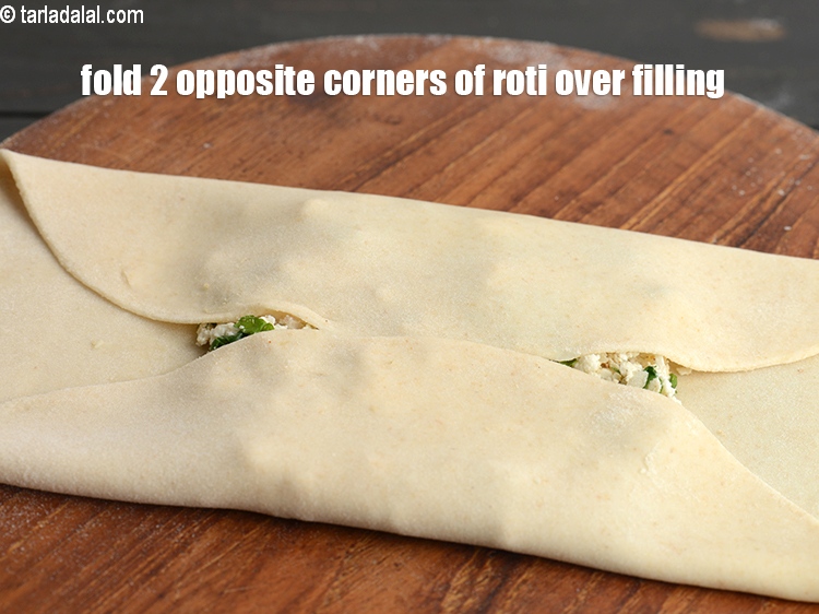 Step 28 – Fold 2 opposite corners of the roti over the filling, overlapping them slightly.