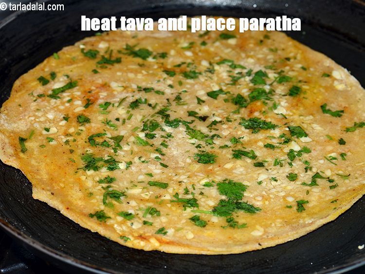 Step 26 – Heat a non-stick tava (griddle) and place the paratha.