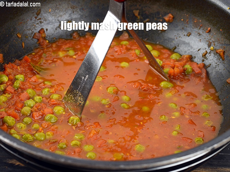 Step 26 – Lightly mash the green peas using a potato masher.