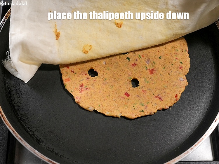 Step 27 – Heat a non-stick tava (griddle), place the thalipeeth upside down.
