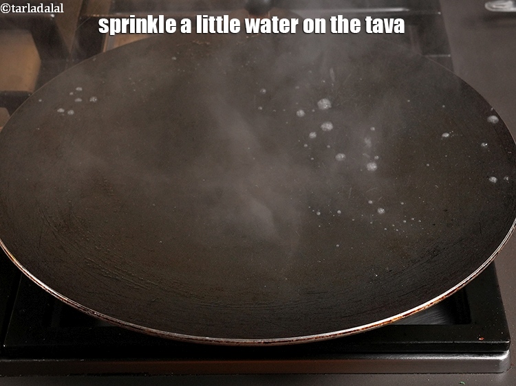 Step 26 – Sprinkle a little water on the tava (griddle).