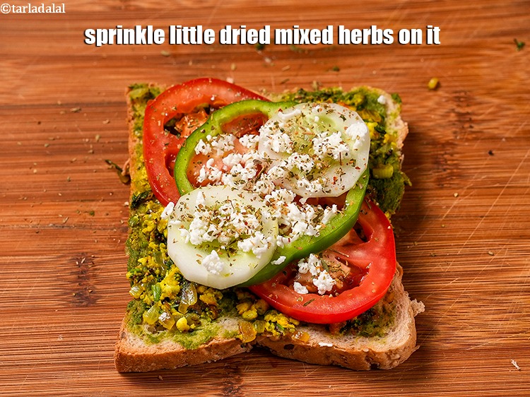 Step 26 – Sprinkle little <a href="https://www.tarladalal.com/glossary-dried-mixed-herbs-466i">dried mixed herbs</a>&nbsp;on it.