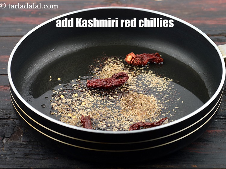 Step 26 – Add 2&nbsp;<a href="https://www.tarladalal.com/glossary-fresh-red-chillies-lal-mirch-lal-mirchi-334i">whole Kashmiri red chillies</a>&nbsp;, broken into pieces