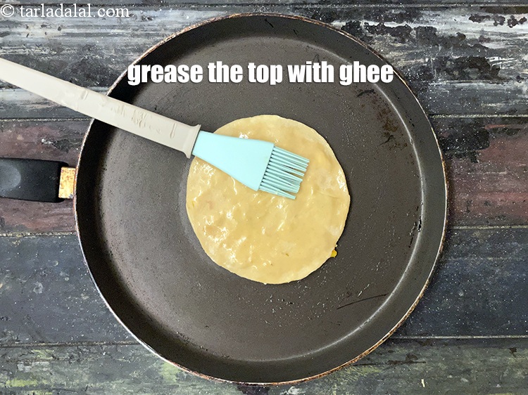 Step 34 – <meta charset="UTF-8" />Grease the top of the paratha with ghee.&nbsp;&nbsp;