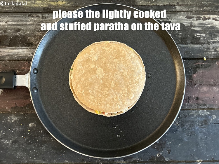 स्टेप 28 – हल्का पका हुआ और भरवां परांठा तवे पर रखें।