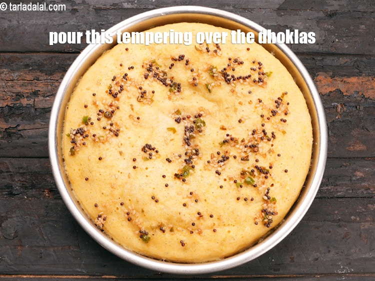 Step 26 – Pour this tempering over the steamed dhoklas.