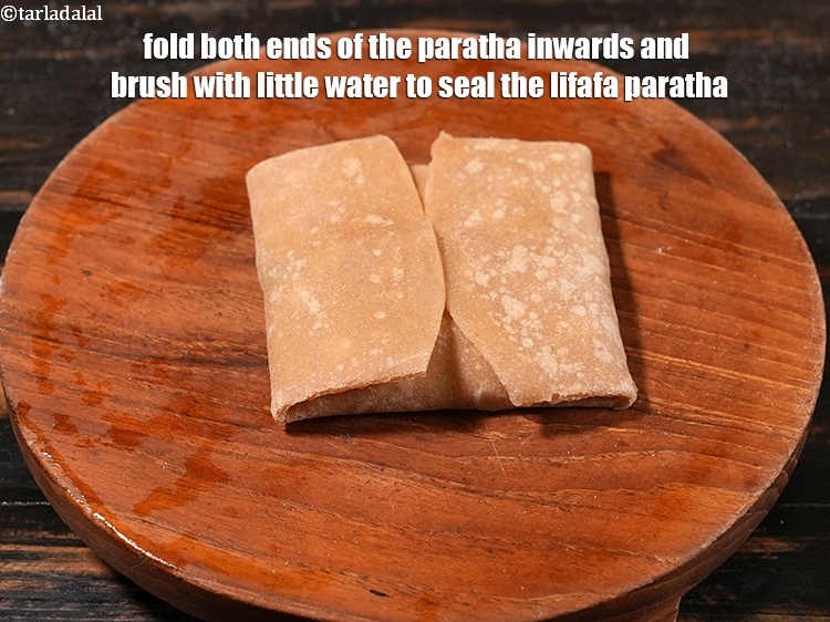 Step 57 – <meta charset="UTF-8" /> Fold both&nbsp;ends of the paratha inwards and brush with little water to …