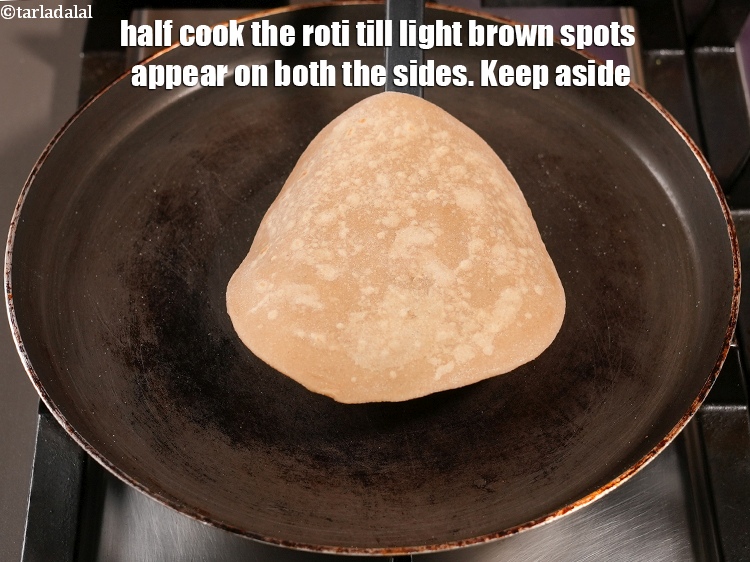 Step 29 – Half cook the roti till light brown spots appear on both the sides. Keep aside.