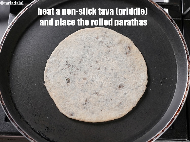 Step 28 – Heat a non-stick tava (griddle) and place the rolled parathas.