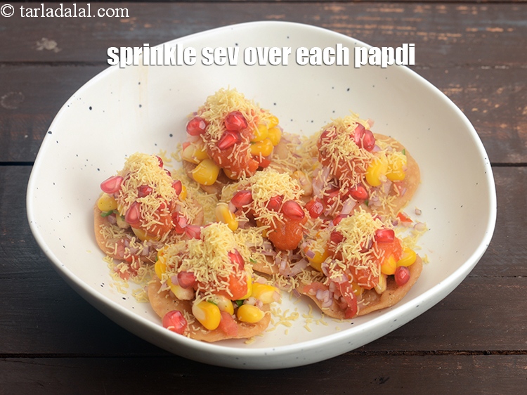 Step 33 – Also sprinkle &frac12; tsp of nylon&nbsp;<a href="https://www.tarladalal.com/sev-2791r">sev</a>&nbsp;over each papdi.