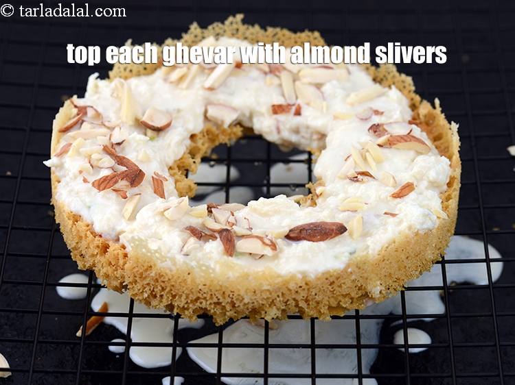 स्टेप 29 – प्रत्येक घेवर के ऊपर &frac12; बड़े चम्मच&nbsp;&nbsp;<a href=""https://tarladalal.com/glossary-almond-slivers-slivered-almonds-hindi-664i"" target=""_blank"">बादाम की …