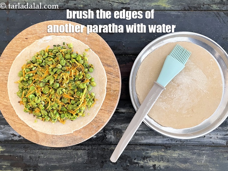 Step 29 – Brush the edges of another paratha with water.