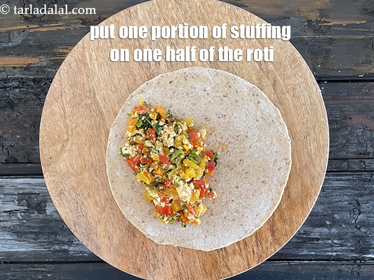 स्टेप 29 – रोटी के आधे भाग पर भरावन का एक भाग रखें।