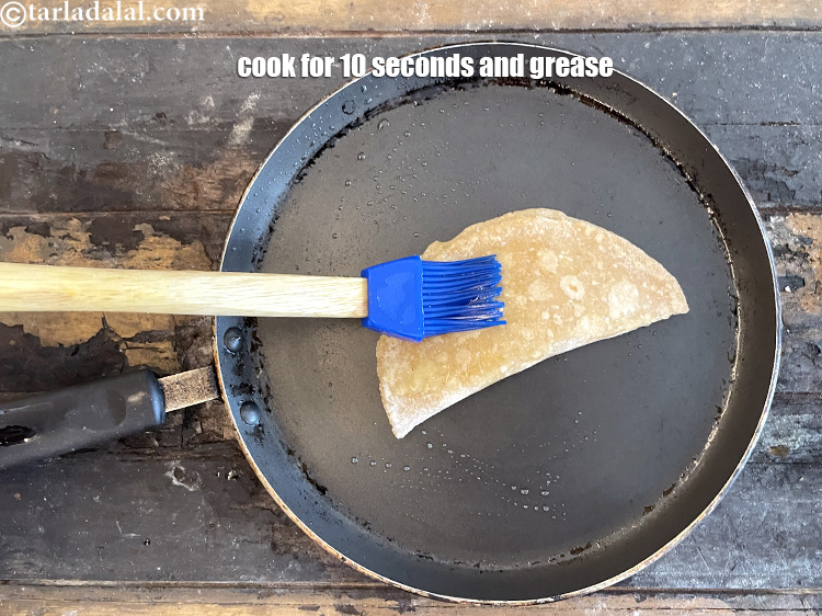 Step 28 – Cook the roti for 10 seconds and grease the top. Remember to press down with …