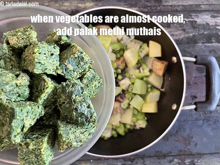 Step 28 – <meta charset="UTF-8" />When the vegetables are almost cooked, add the palak methi na muthias. See …