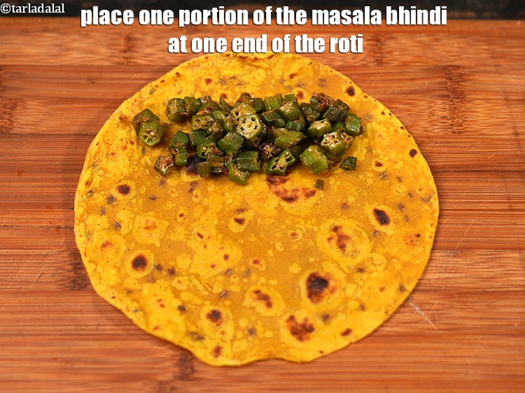 Step 28 – Place one portion of the masala bhindi at one end of the roti.