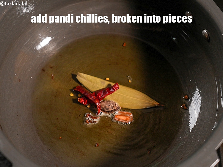 Step 28 – Add 1 dry <a href="https://www.tarladalal.com/glossary-pandi-chillies-pandi-dry-red-chillies-2373i">pandi chillies</a>, broken into pieces.