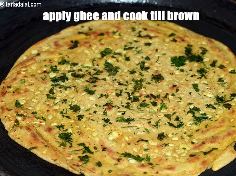 Step 28 – Apply 2 tsp little&nbsp;<a href="https://www.tarladalal.com/glossary-ghee-245i">ghee</a>, till brown spots appear on both the sides.