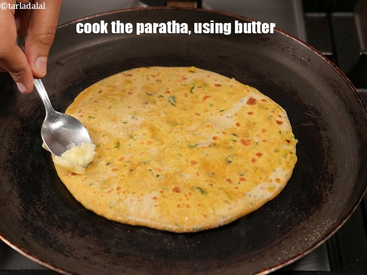 Step 28 – Cook the paratha, using &frac12; tsp of <a href="https://www.tarladalal.com/glossary-butter-makhan-233i">butter</a>.