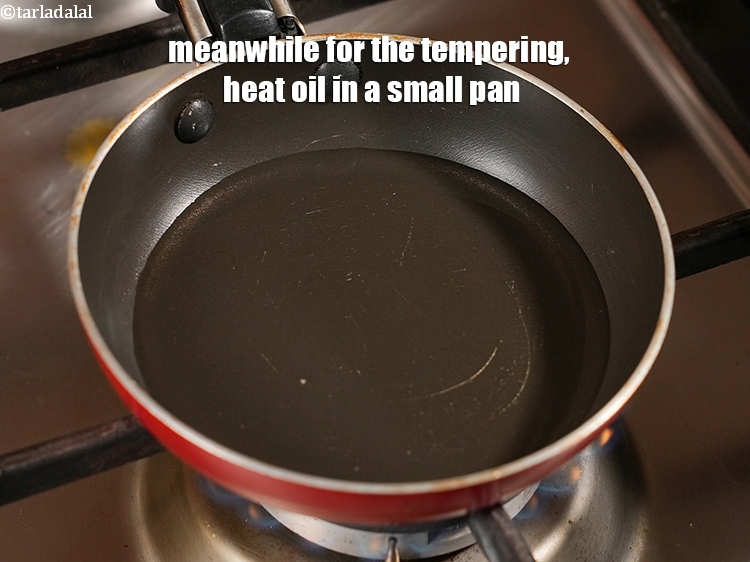 Step 28 – Meanwhile for the tempering, heat 1 tbsp <a href="https://www.tarladalal.com/glossary-oil-671i">oil</a> in a small pan.