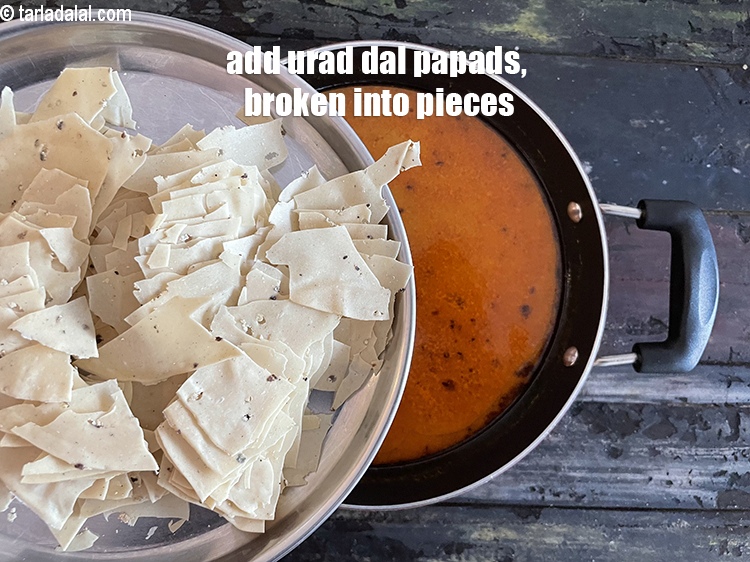Step 30 – Add&nbsp;<meta charset="UTF-8" />6&nbsp;medium sized raw urad dal&nbsp;<a href="glossary-papad-papadum-562i">papad</a>s , broken into small pieces.