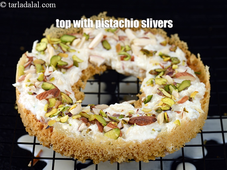 स्टेप 30 – ऊपर से &frac12; बड़े चम्मच&nbsp;<a href=""https://tarladalal.com/glossary-pistachios-pista-hindi-891i"" target=""_blank"">पिस्ता की कतरन</a>&nbsp;डालें।&nbsp;&nbsp;