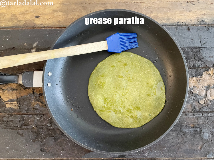 स्टेप 55 – पराठे के ऊपर तेल से थोड़ा ग्रीस कर लें।