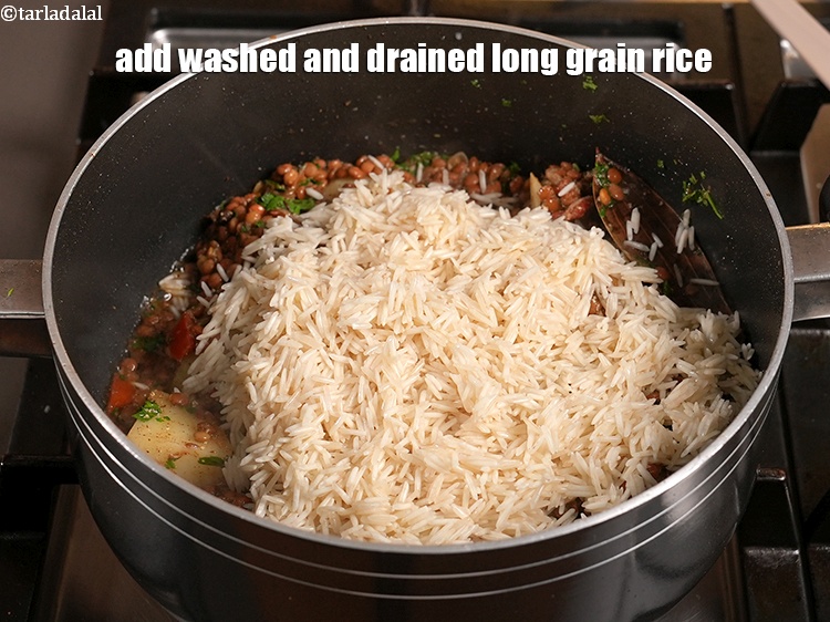 Step 29 – Add 1&frac14; cups washed and drained <a href="https://www.tarladalal.com/glossary-long-grain-rice-basmati-chawal-basmati-rice-535i">long grain rice (basmati chawal)</a>.