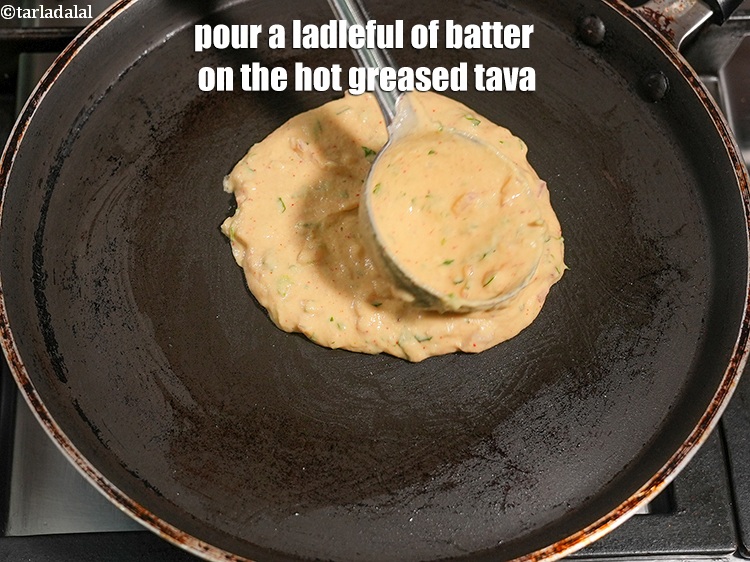 Step 29 – Pour a ladleful of batter on the hot greased tava.