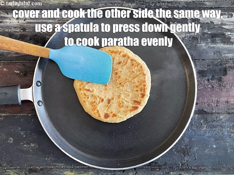 स्टेप 29 – दूसरी तरफ भी इसी तरह पकाएं और पराठे को समान …