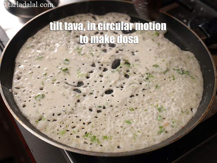 Step 30 – Tilt the tava (griddle), in a circular motion to make a round dosa.