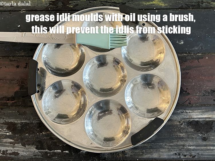 स्टेप 29 – इडली के सांचों को ब्रश से तेल लगाकर चिकना कर …