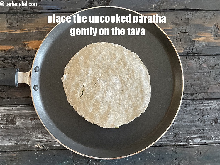 Step 30 – Place the uncooked paratha on the tava. Note the paratha is fragile as its made …