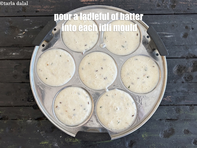 Step 30 – <p>Pour a ladleful of batter into each greased idli mould.</p>
