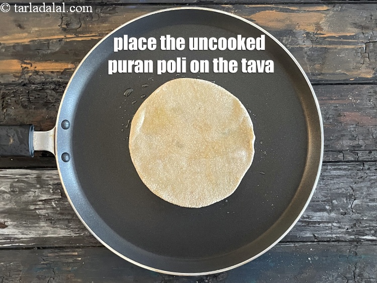 Step 29 – <meta charset="UTF-8" />Place the uncooked puran poli gently on the tava.&nbsp;&nbsp;&nbsp;&nbsp;