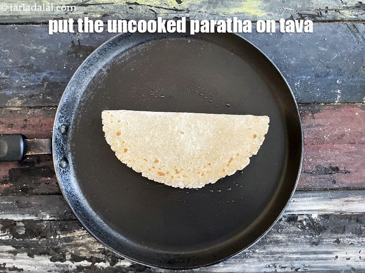 Step 32 – Place the uncooked stuffed bajra paratha on the tava and cook for 15 seconds.