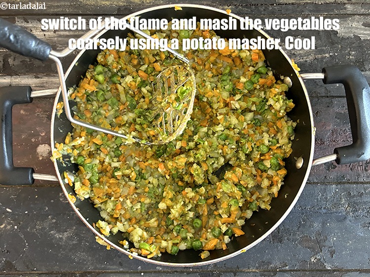 Step 29 – Switch off the flame and mash the vegetables coarsely using a potato masher. Cool.