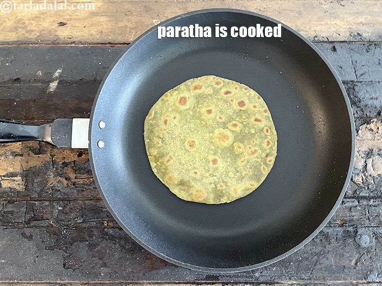 स्टेप 56 – पलटें और सुनहरे दाग पड़ने तक पका लें। पराठा पक …