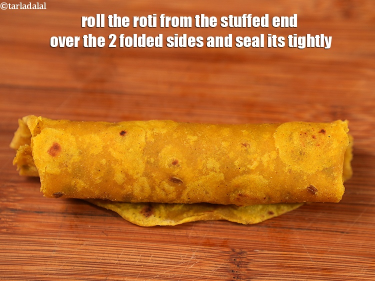 Step 30 – Roll the roti from the stuffed end over the 2 folded sides and seal its …